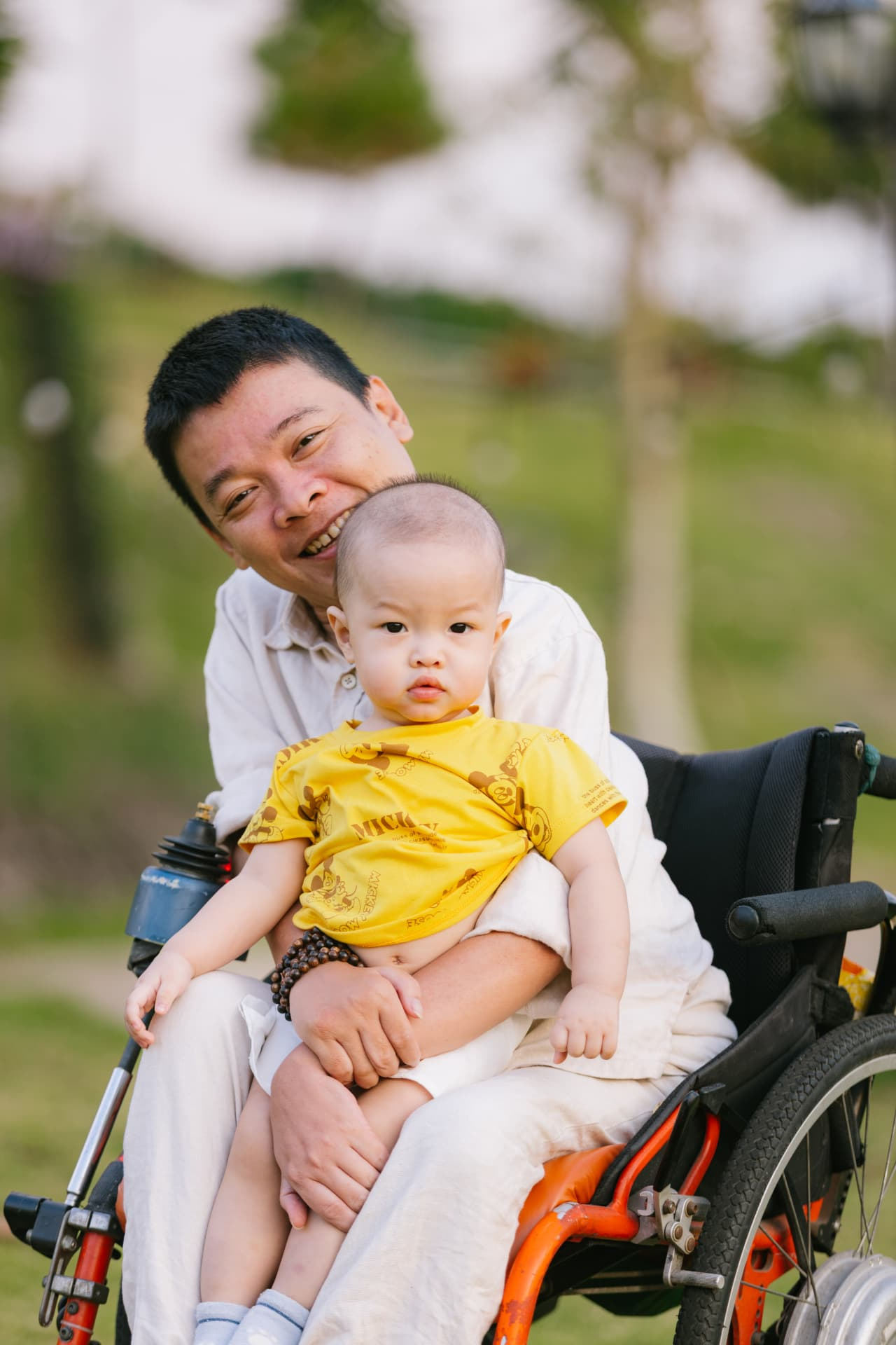 A father holding his son close in the park